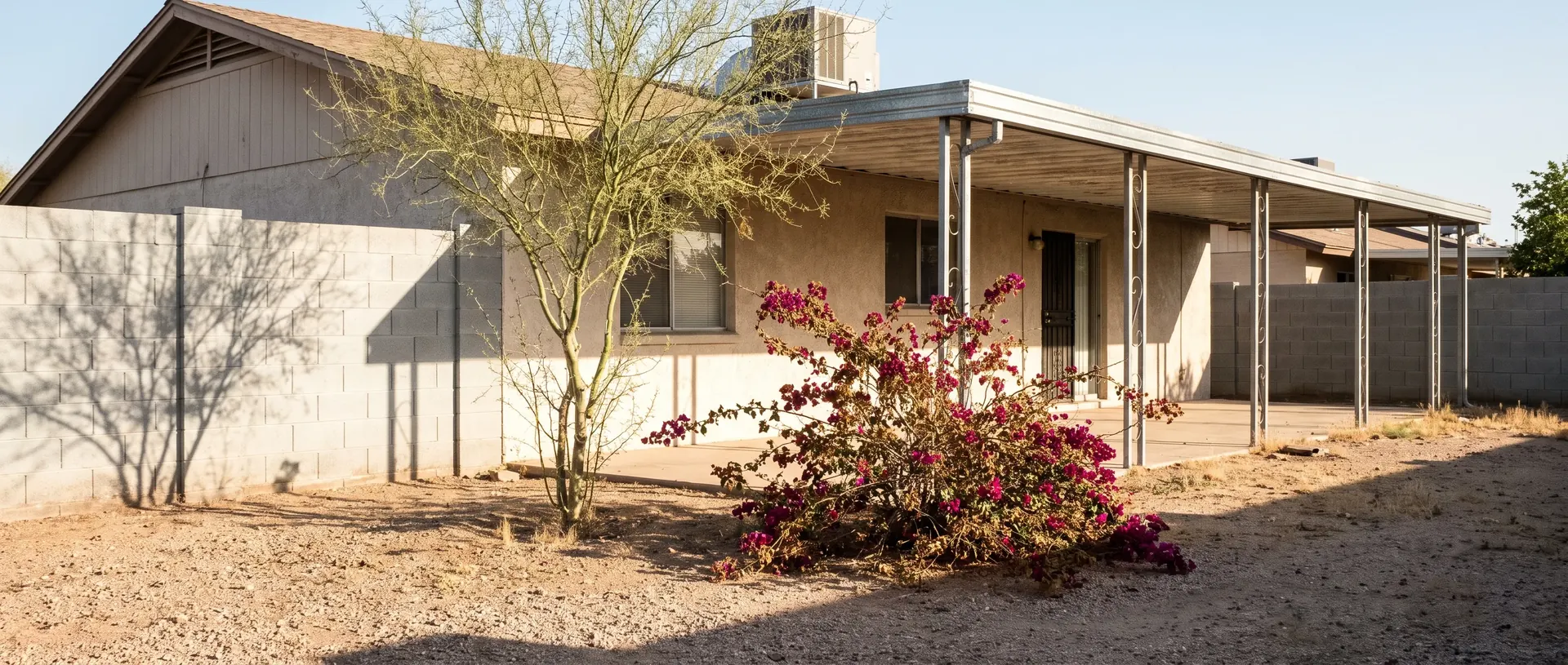 Metal patio roof and gravel yard at a Phoenix home in the afternoon
