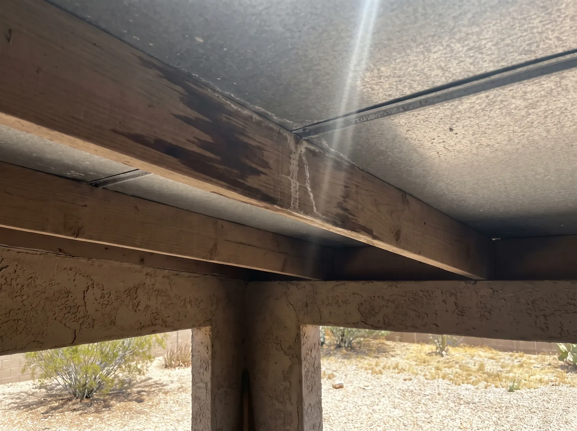 Water stain tracking along a roof purlin above a metal panel seam